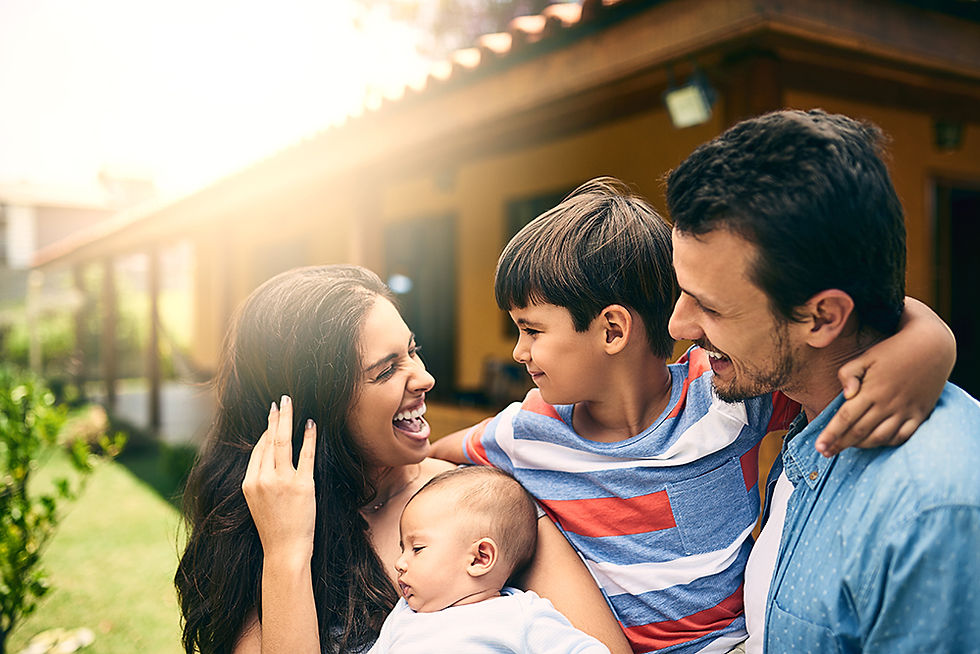 Happy Indian family outside of house in bright sun