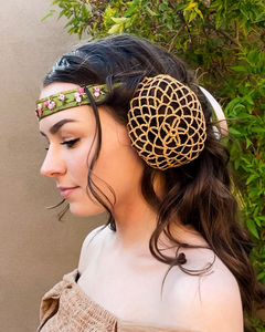 The profile view of a dark haired girl looking down. Her hair is curled, with a green headband across her forehead and a bun on the side of her head with a gold crocheted bun cover over it.