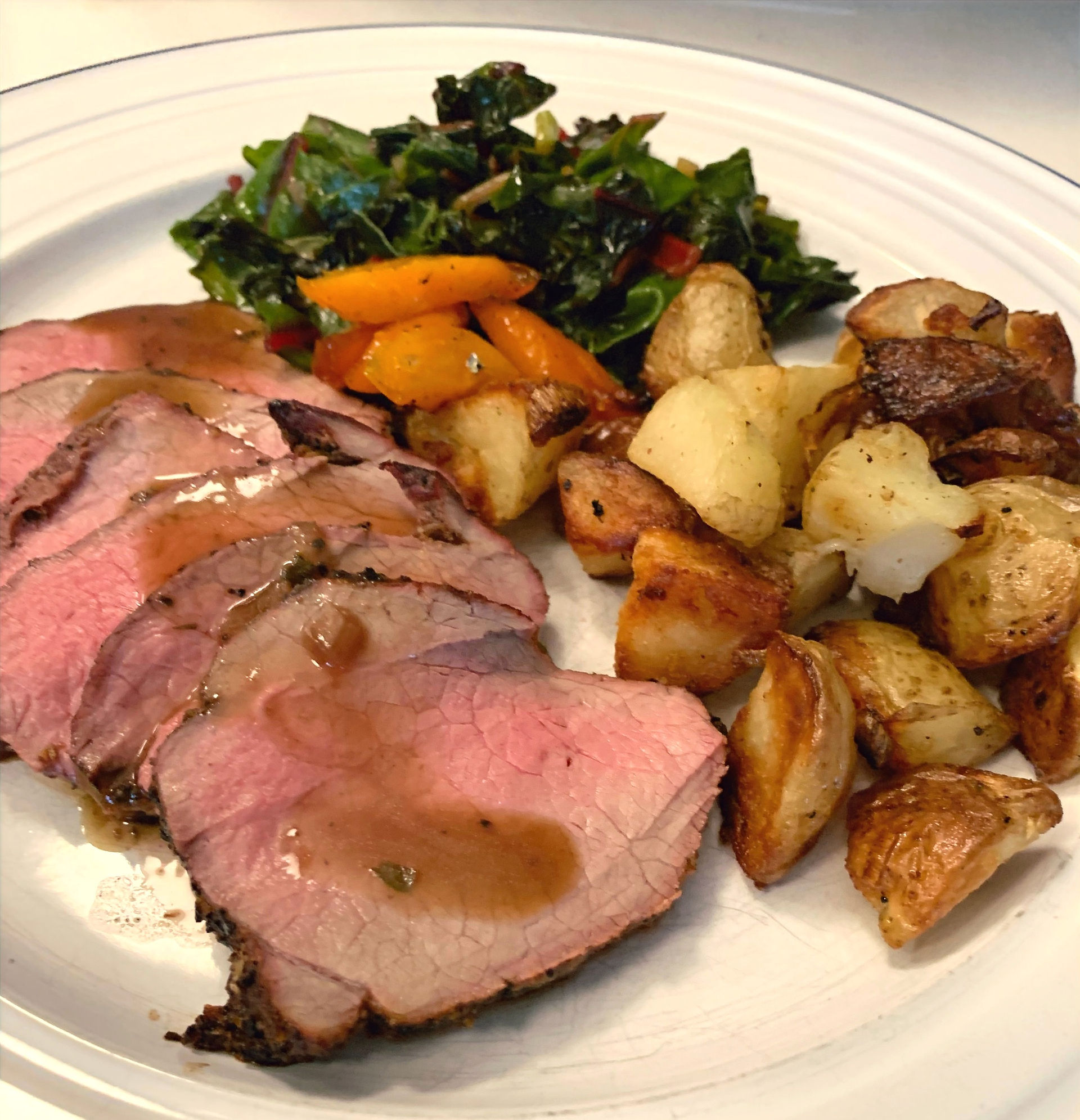 Slices of roast pork, potatoes, and greens celebrating French Canadian culinary heritage.