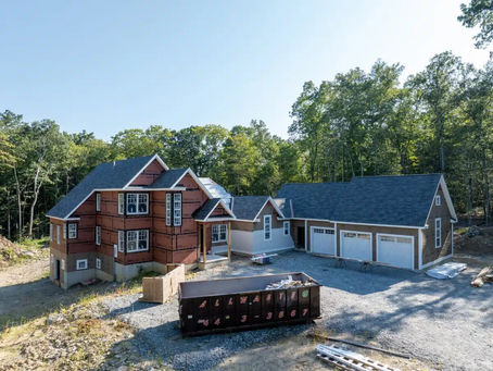 A serene, beautifully constructed luxury Connecticut home surrounded by mature landscaping and soft natural light. The exterior highlights finely crafted architectural details, including custom millwork, expansive windows, and high-quality materials that reflect expert craftsmanship. The image showcases the level of precision associated with a home builder near me, premium custom home builders, and coastal or green building specialists. The outdoor setting illustrates a balance between modern design and timeless aesthetics, representing the refined construction, thoughtful planning, and long-term durability offered by Uccello Fine Homes.