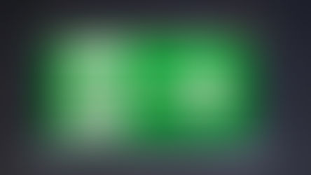 Green exit sign showing a figure running through a door with a right arrow, suspended against a dark, blurred ceiling background.