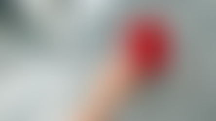 Hand pressing a red fire alarm button in a long, empty corridor. The wall is gray with a speckled pattern. The button reads "FIRE."