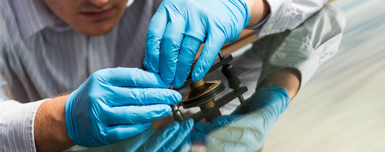 Man repairing chip in an automobile windshield