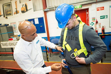 A training instructor demonstrating how to fasten a safety harness