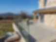 Outdoor area with glass balustrade and seating, overlooking countryside