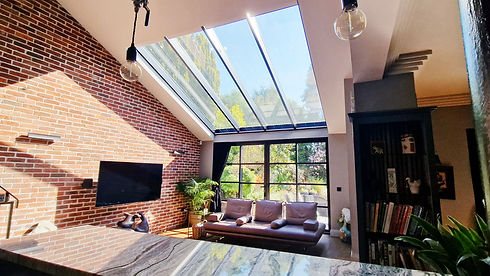 Sunlight streaming in through a large skylight window into a house extension.