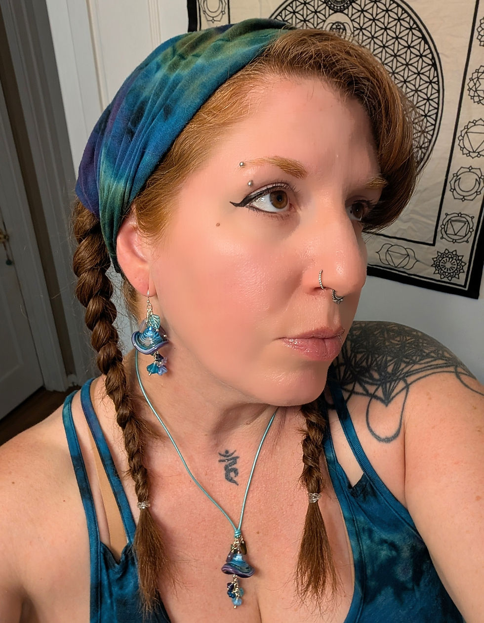 Thumbnail: red haired woman wearing a tie dye headband with floral lampwork earrings and necklace