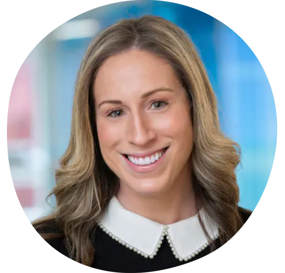 Jenny Holmes with blond hair smiling with white collar and black shirt