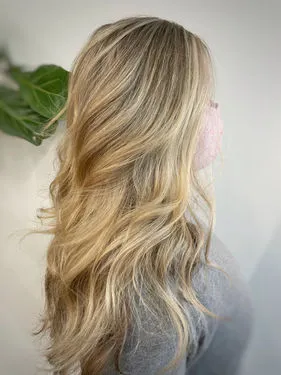 Long blonde hair showing a blended extension transformation with soft waves