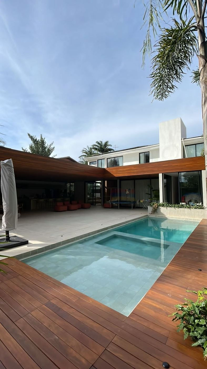 Piscina pastilhada com deck de madeira em residência em Brasília