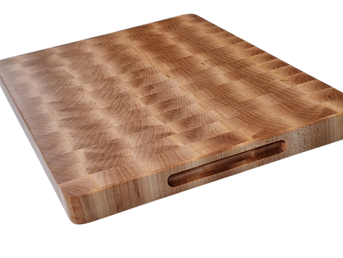 A thick, square end-grain wooden cutting board is prominently displayed, exhibiting a distinctive checkerboard pattern formed