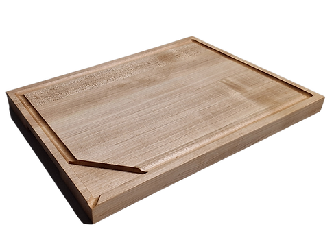 A light-colored wooden cutting board with a prominent grain pattern is presented against a dark background, showcasing its sturdy construction. The board features a practical juice-collecting groove along its outer edge and a subtle raised rim.
