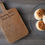 Thumbnail: The image showcases a wooden cutting board with a handwritten recipe for "Granny Pat's Plain Scones," alongside a glass plate