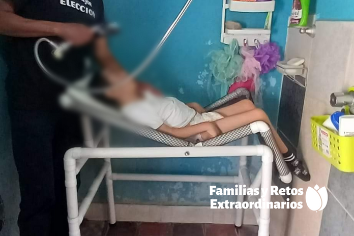 Efrain pretending to bathe his son Tadeo in a shower chair designed by Kevin's dad.