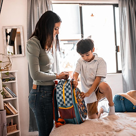 Parent helping child prepare for school during a co-parenting transition