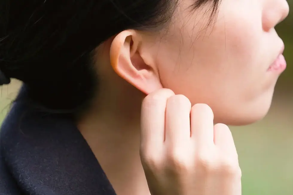 woman tugging on ear for a vagus nerve reset to help with a more holistic lifestyle
