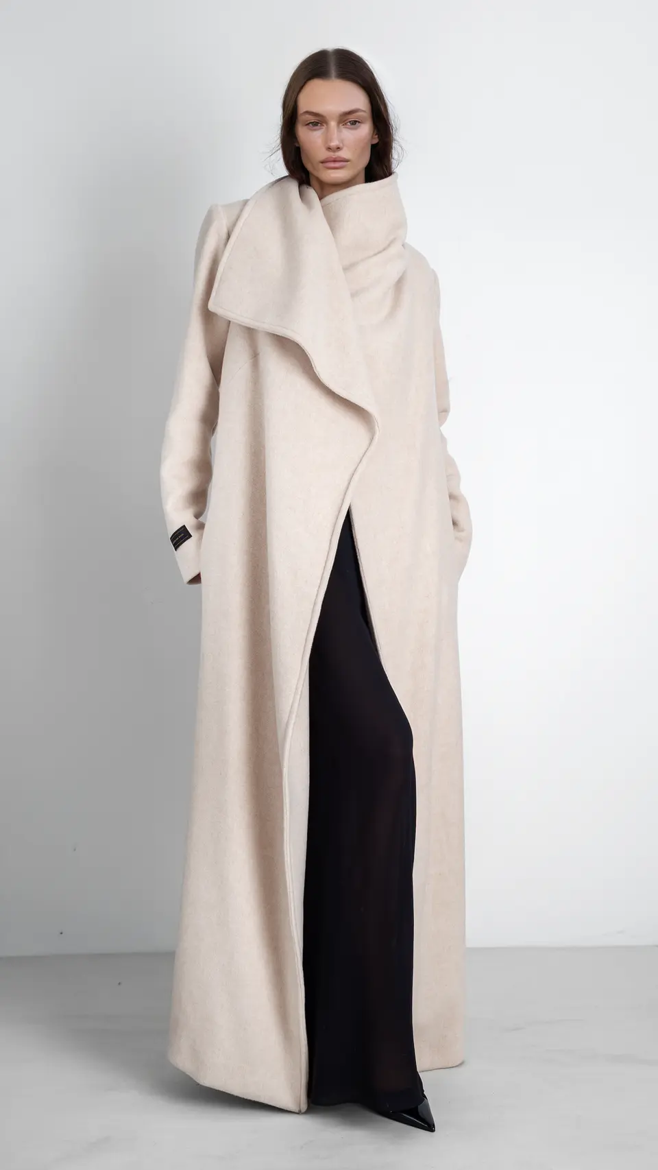 Maxi abrigo de cashmere color crudo con cuello amplio y líneas limpias. vista cerrado