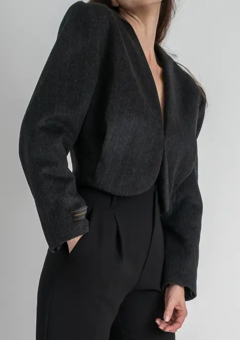 Detalle lateral de chaqueta corta de cashmere con hombros marcados y corte arquitectónico