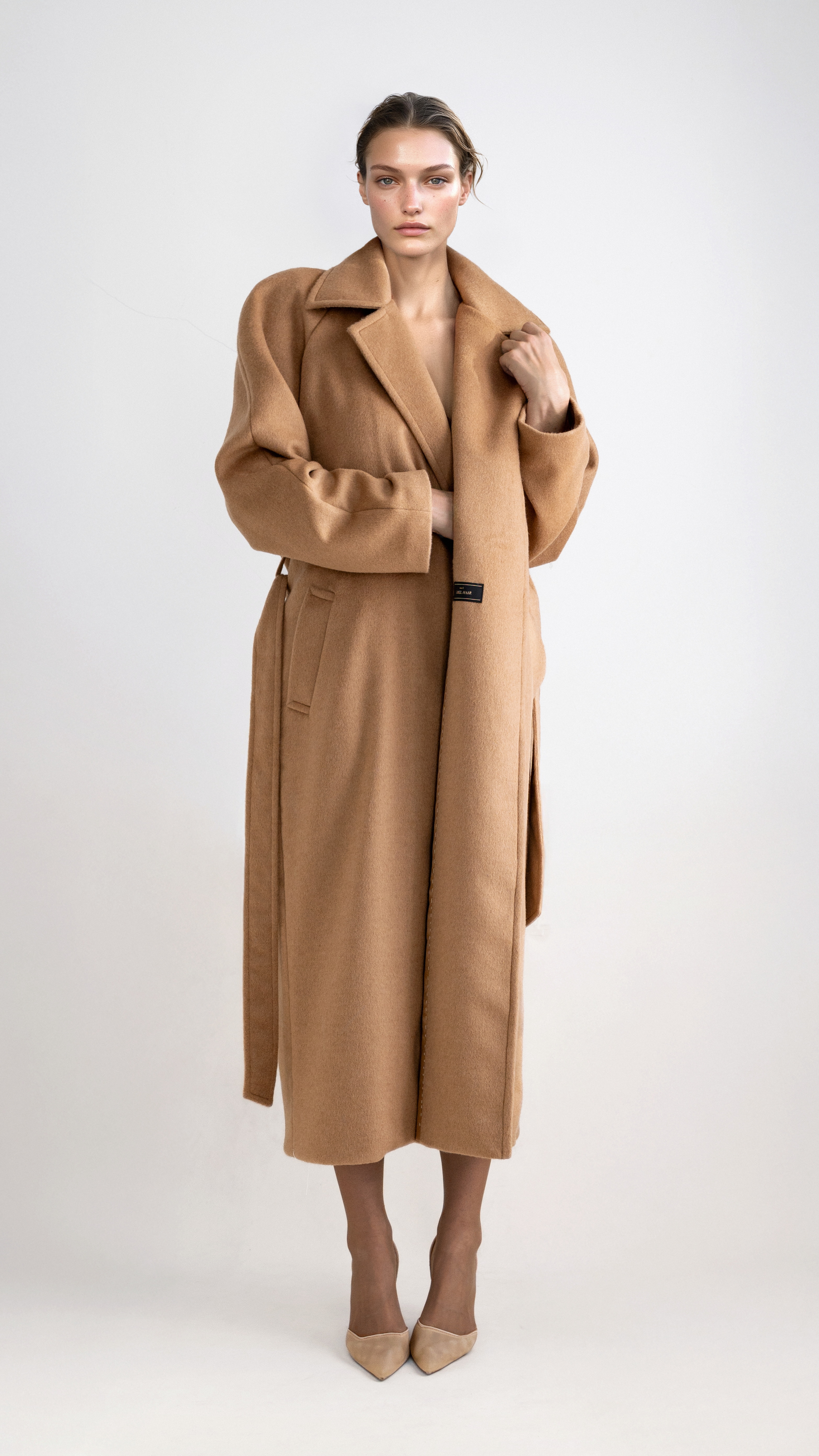 Modelo vistiendo abrigo camel con cinturón de lana de camello auténtica – estilo elegante y sostenible