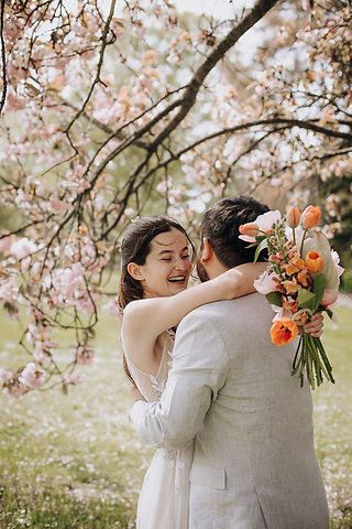 Happy couple embraces under blossoming tree