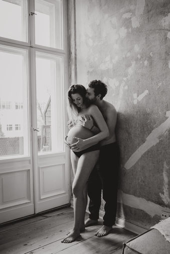 Pregnant couple embracing, black and white photo