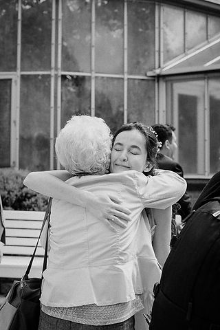 Bride and guest embrace at wedding