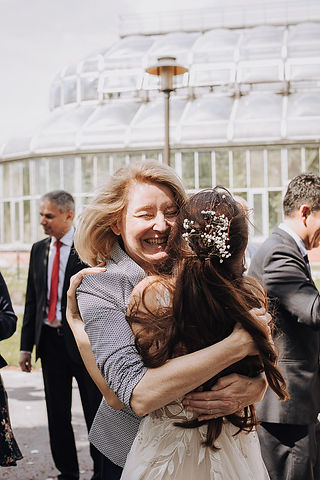 Happy bride hugs guest at spring wedding