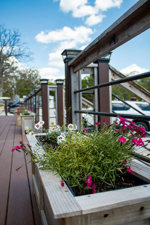 Wooden deck with railing, flowers blooming, blue sky, and other vehicles rv parks in joplin missouri