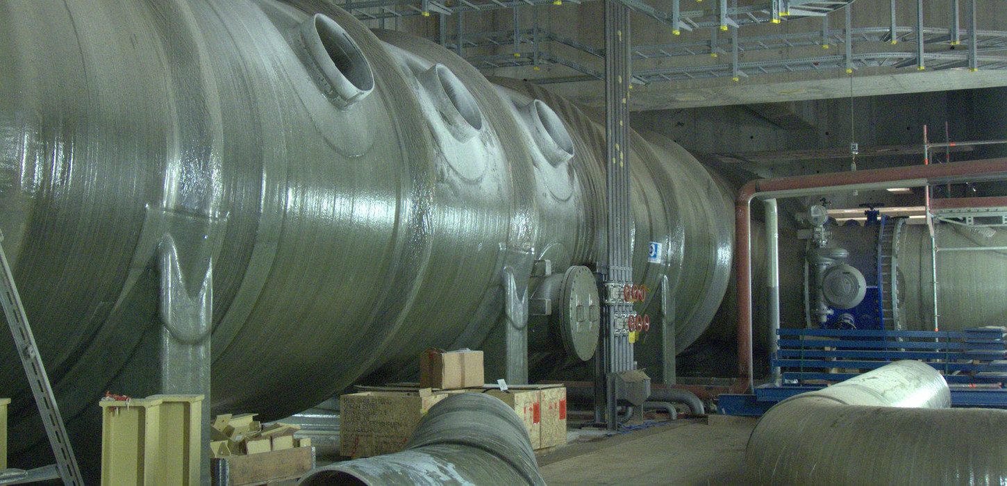In einer Industrieanlage werden massive Fiberglastanks und -rohre gebaut.