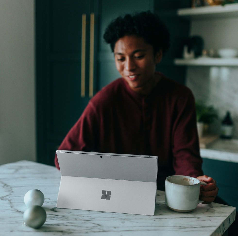 Woman drinking coffee smiling at the screen of her Microsoft Surface tablet