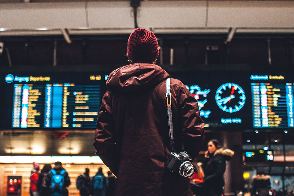 Traveler standing in airport with camera over shoulder