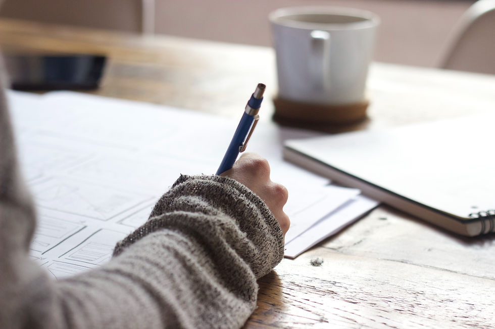 Person writing on papers on a desk
