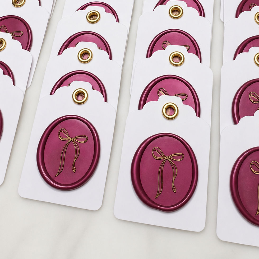 rows of custom gift tags with a wax seal in ruby red and a bow imprint on them