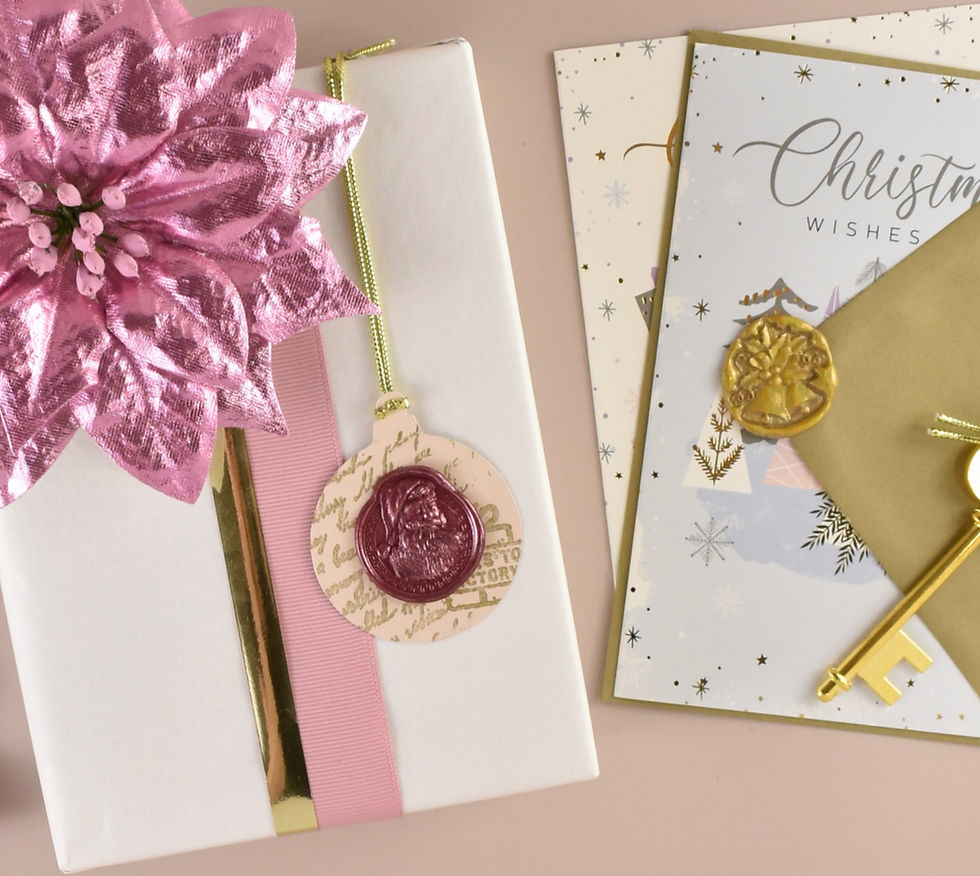 Eye-level view of a gift box with a gold wax seal and Christmas card with a gold wax seal