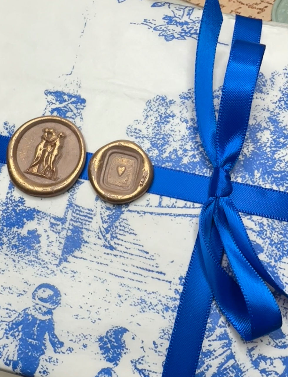Close-up view of wax seal on gift wrapping with ribbon