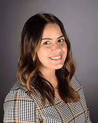Asssitant principal in portrait photography setting wearing a plaid top.