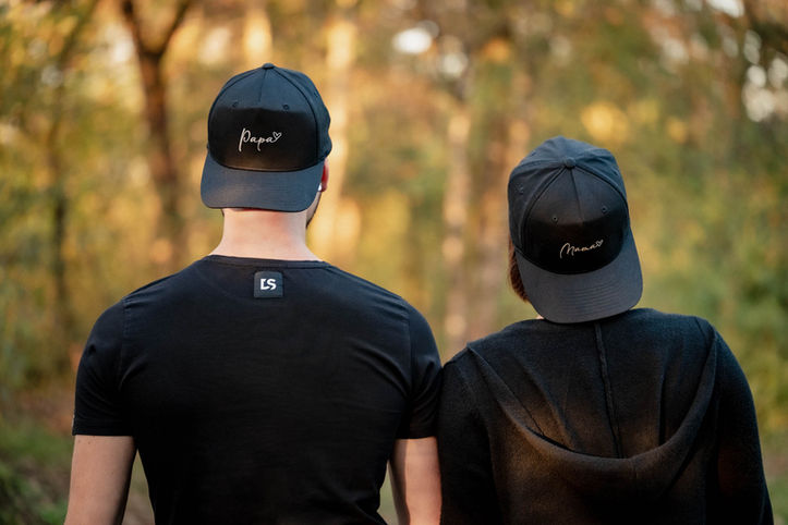 Schwangerschaftsfotografie in der Natur im Herbst, Babybauch im Mittelpunkt, Mama und Papa nah beieinander