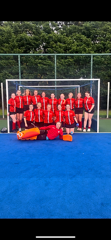 SU Hockey team grouped together in front of goal for photo