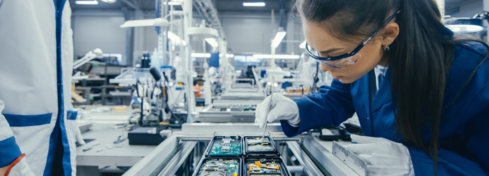 Technician assembling electronics in a manufacturing plant.
