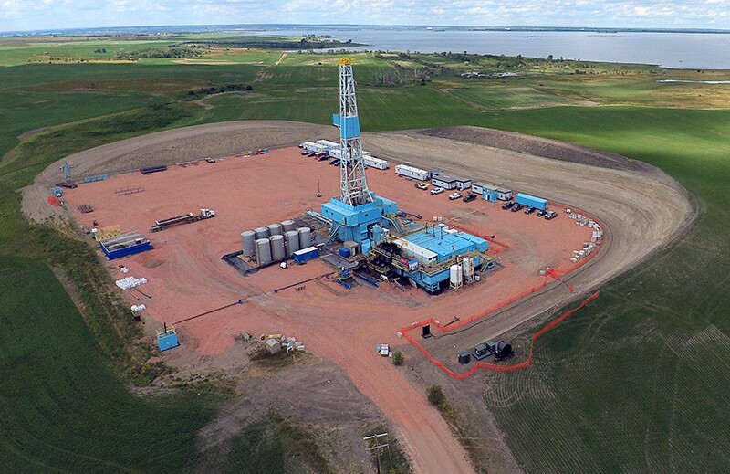 Aerial view of an oil drilling rig in a rural field.
