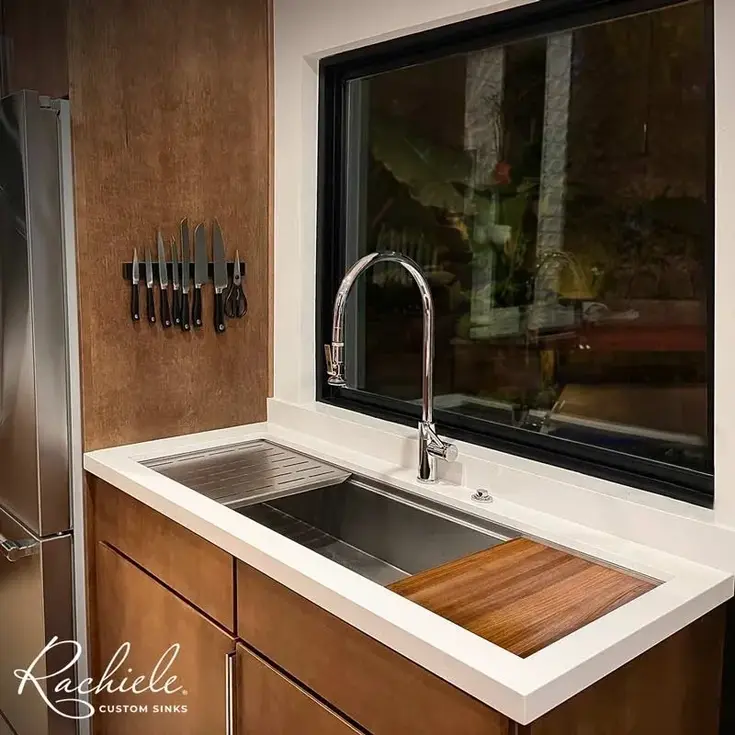 Stainless steel sink with Rachiele logo, wood countertop in modern kitchen.