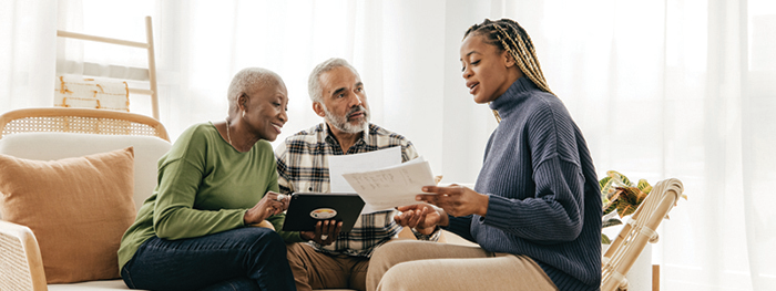 Professional advising a senior couple with documents.