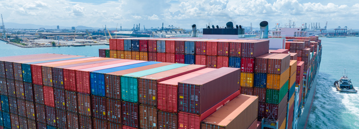 Cargo ship stacked with colorful shipping containers at sea