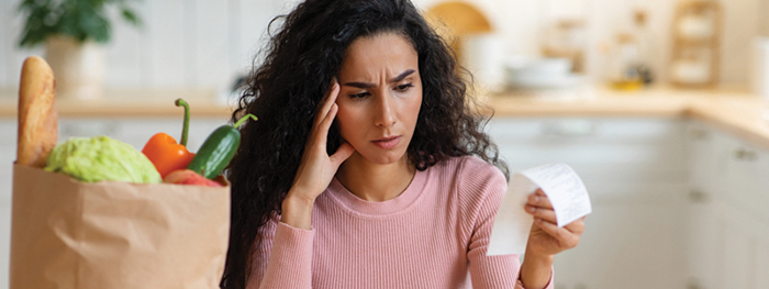 Woman looking stressed while reading a paper receipt