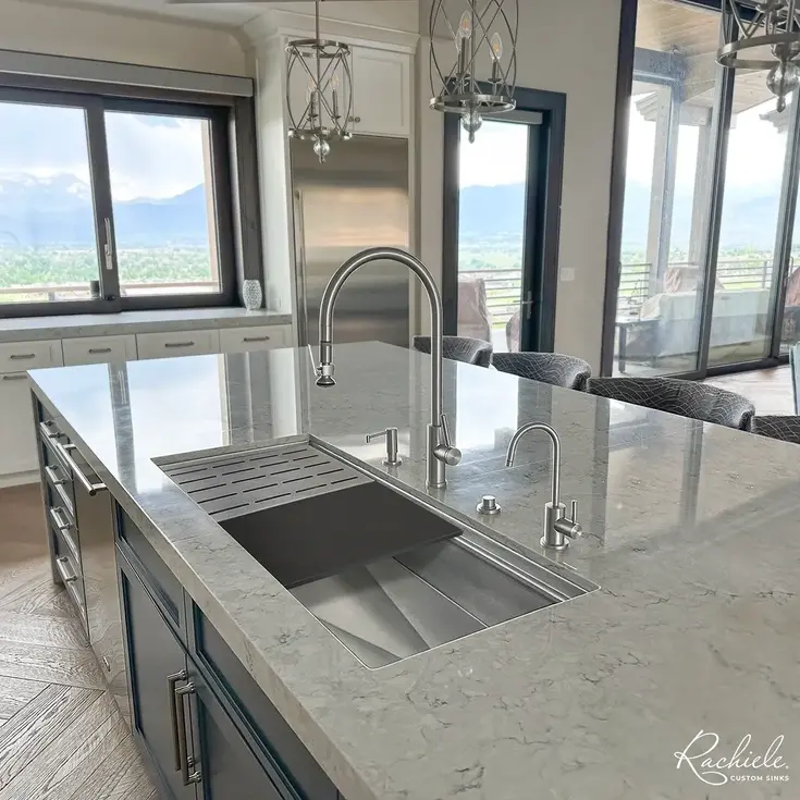 Modern kitchen island with sink and stainless steel appliances. Rachiele
