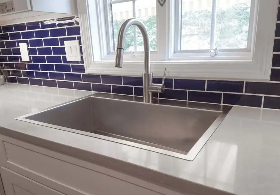 Stainless steel kitchen sink with faucet and blue tile backsplash Rachiele