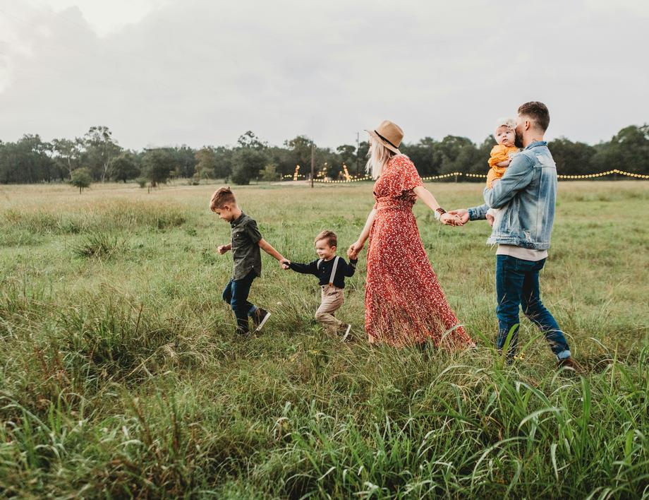 Family walking together through a grassy field