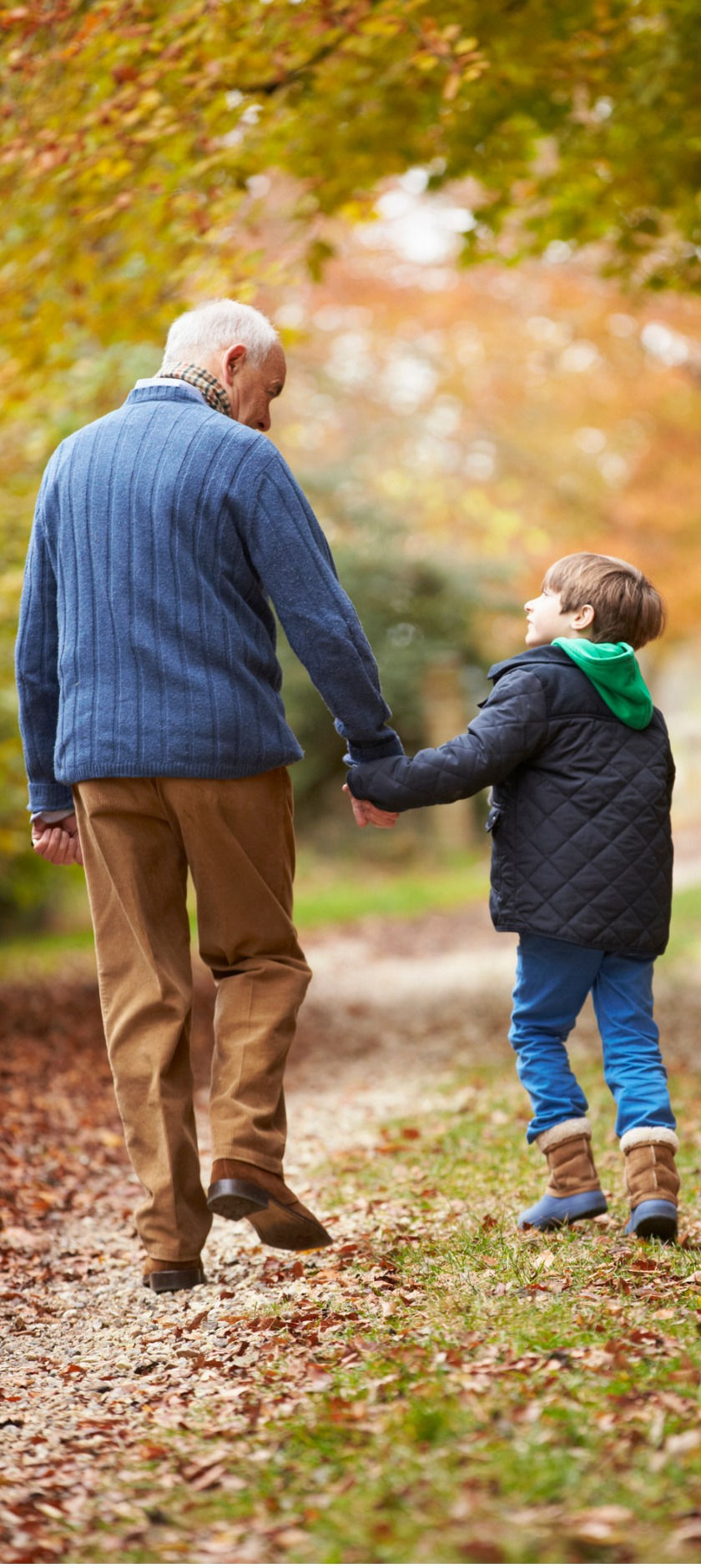 Grandfather and grandson walking in autumn park