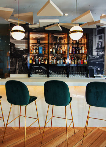 Bar at Tocco Winnetka with green velvet stools, marble top, globe lighting, and Italian mural backdrop by Santini Studio.