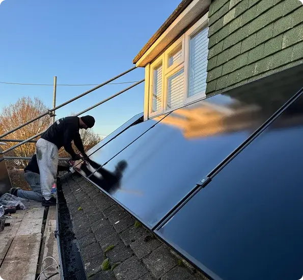 Person installing solar panels on a roof